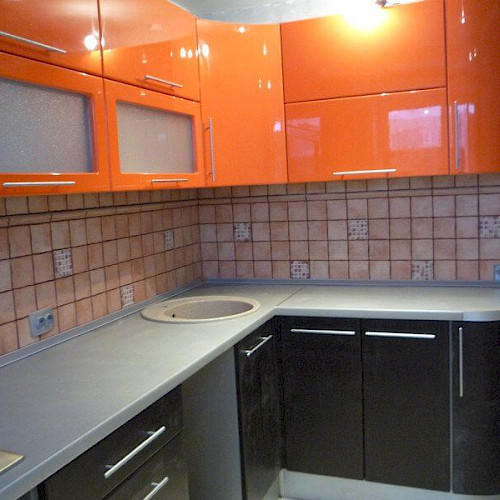 Угловая кухня со стеклом с оранжевыми и чёрными фасадами